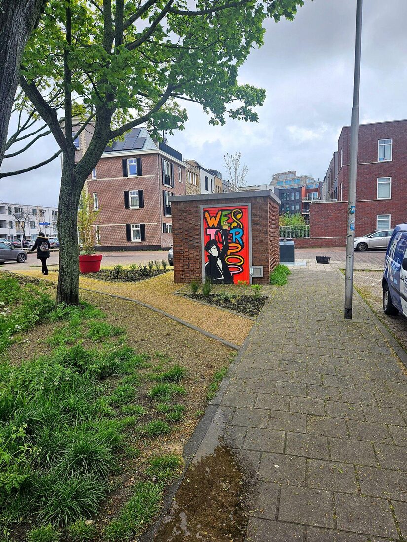 On a street corner in Delft, a gravel path follows the curve people walked across the grass, edged like an official walkway.